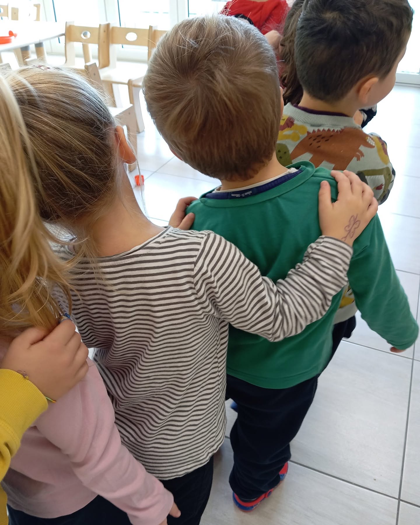 Bambini in fila, uno accanto all’altro, durante un’attività a scuola